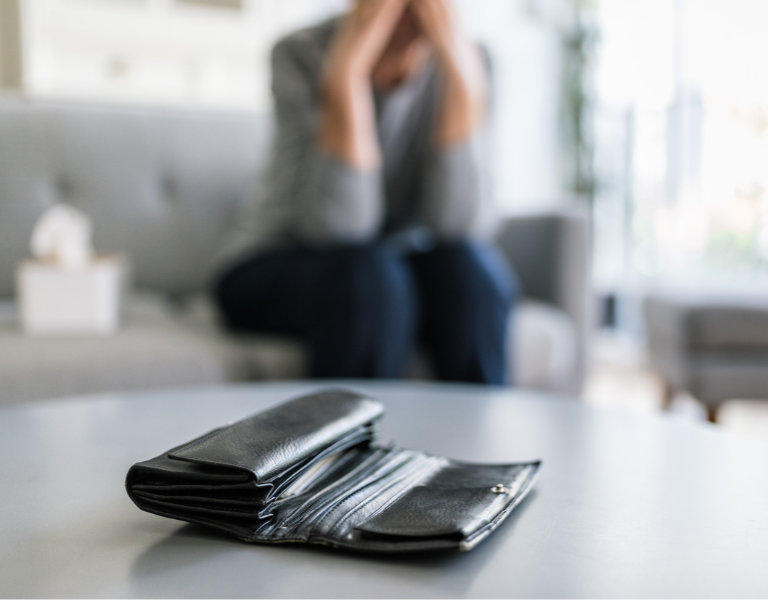 A woman looks worried about her empty purse