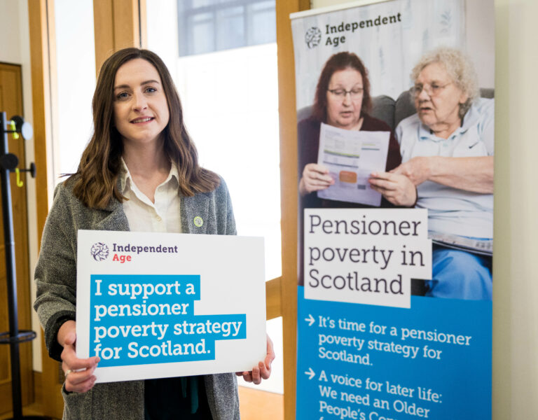 Debbie Horne of Independent Age holding a photo board that says 'I support a pensioner poverty strategy for Scotland'